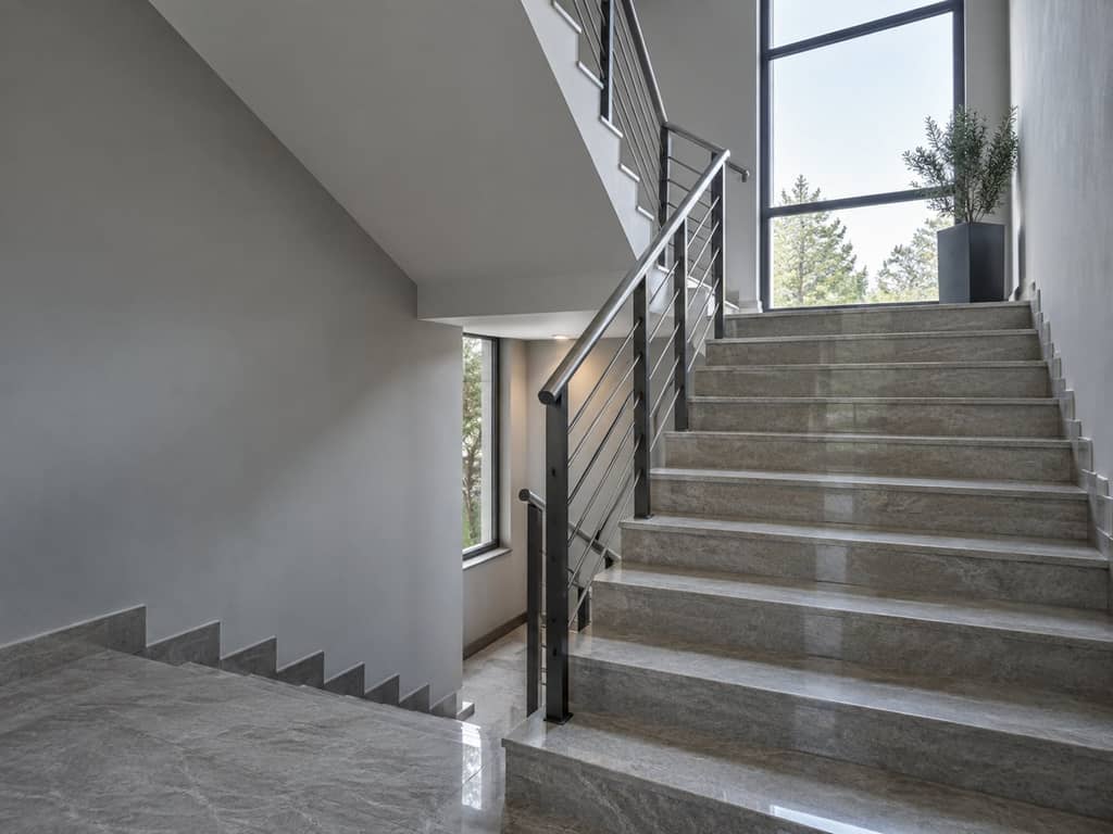 Cage d'escalier de copropriété : marches nettes, rampe et vitrage latéral